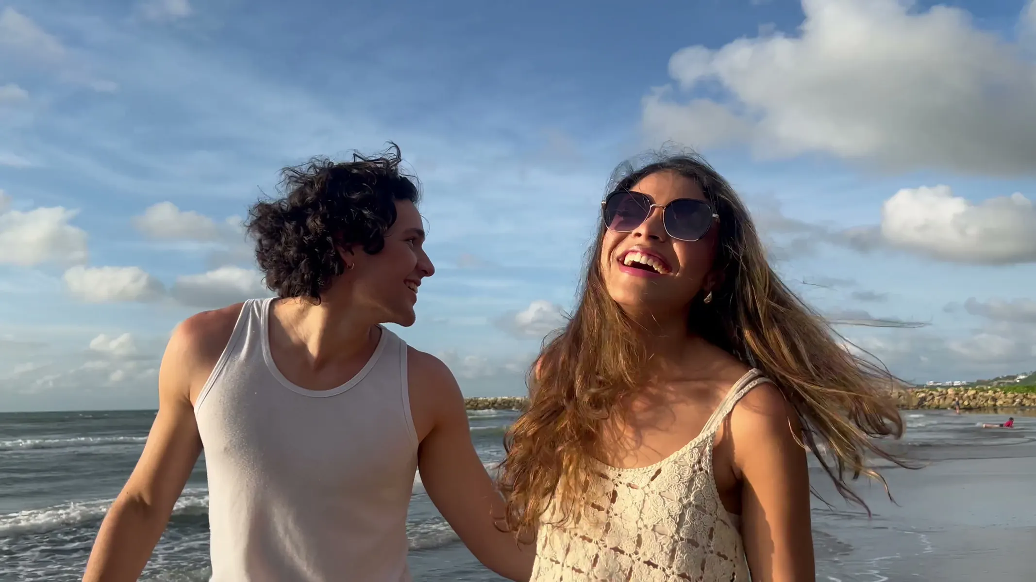 Pareja se ríe junta en una playa del Caribe al atardecer