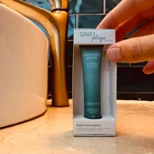Desodorante natural Save a Playa de 20 ml en su caja individual, sobre el lavamanos de un baño