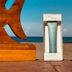 Desodorante natural Save a Playa de 20 ml en su caja, sobre una mesa frente al mar